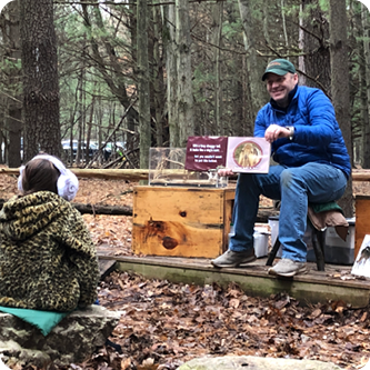 Steve Frisbee reading a book at story time in The Woods Nature Area