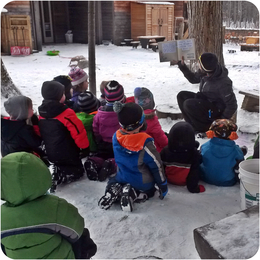 Group of young children enjoy storytime outside in the snow