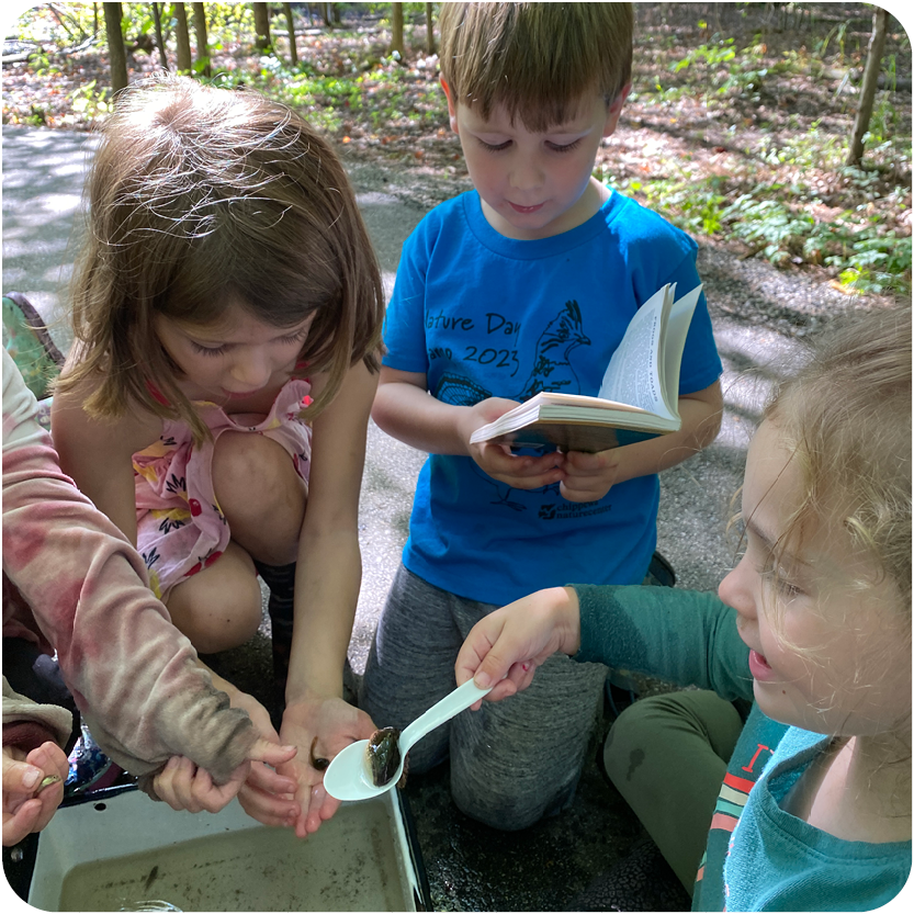 Story Hour - Young children playing outside and reading a book