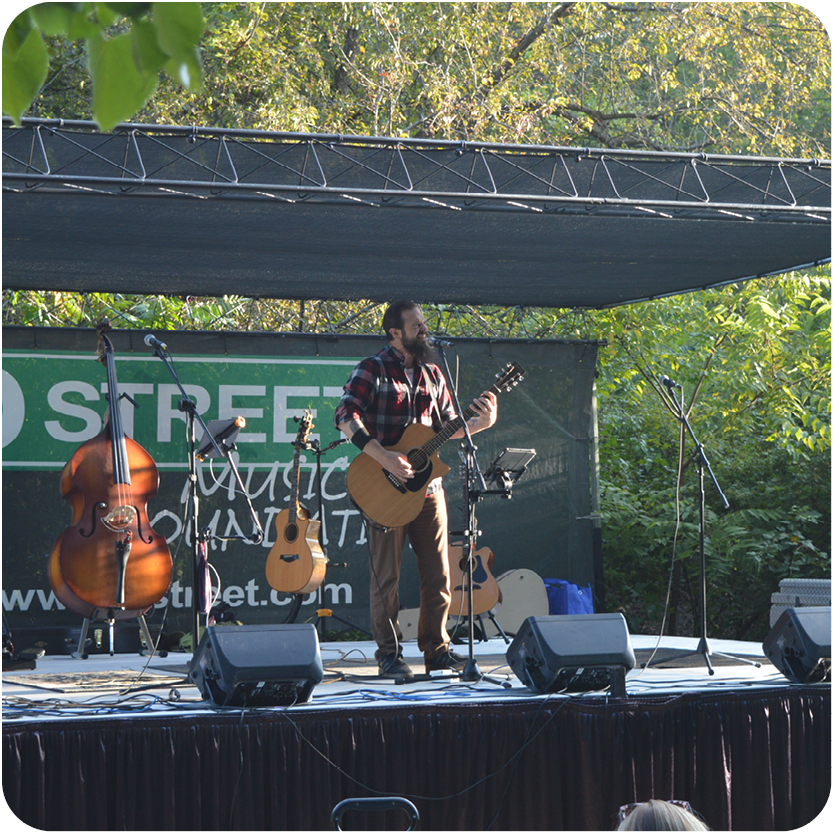 Guitar player on stage outside performing live