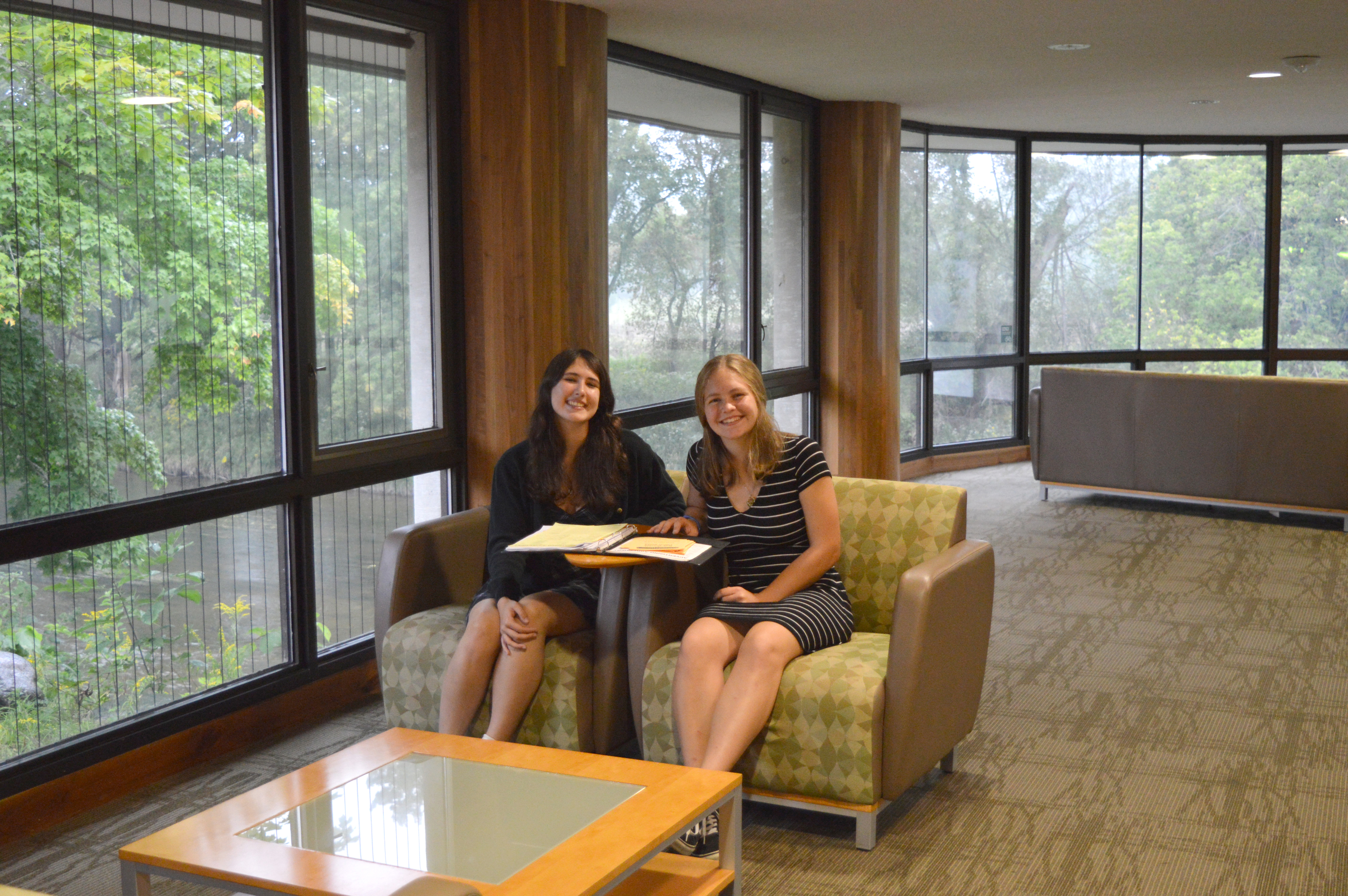 Two Girls sitting in study area with a binder